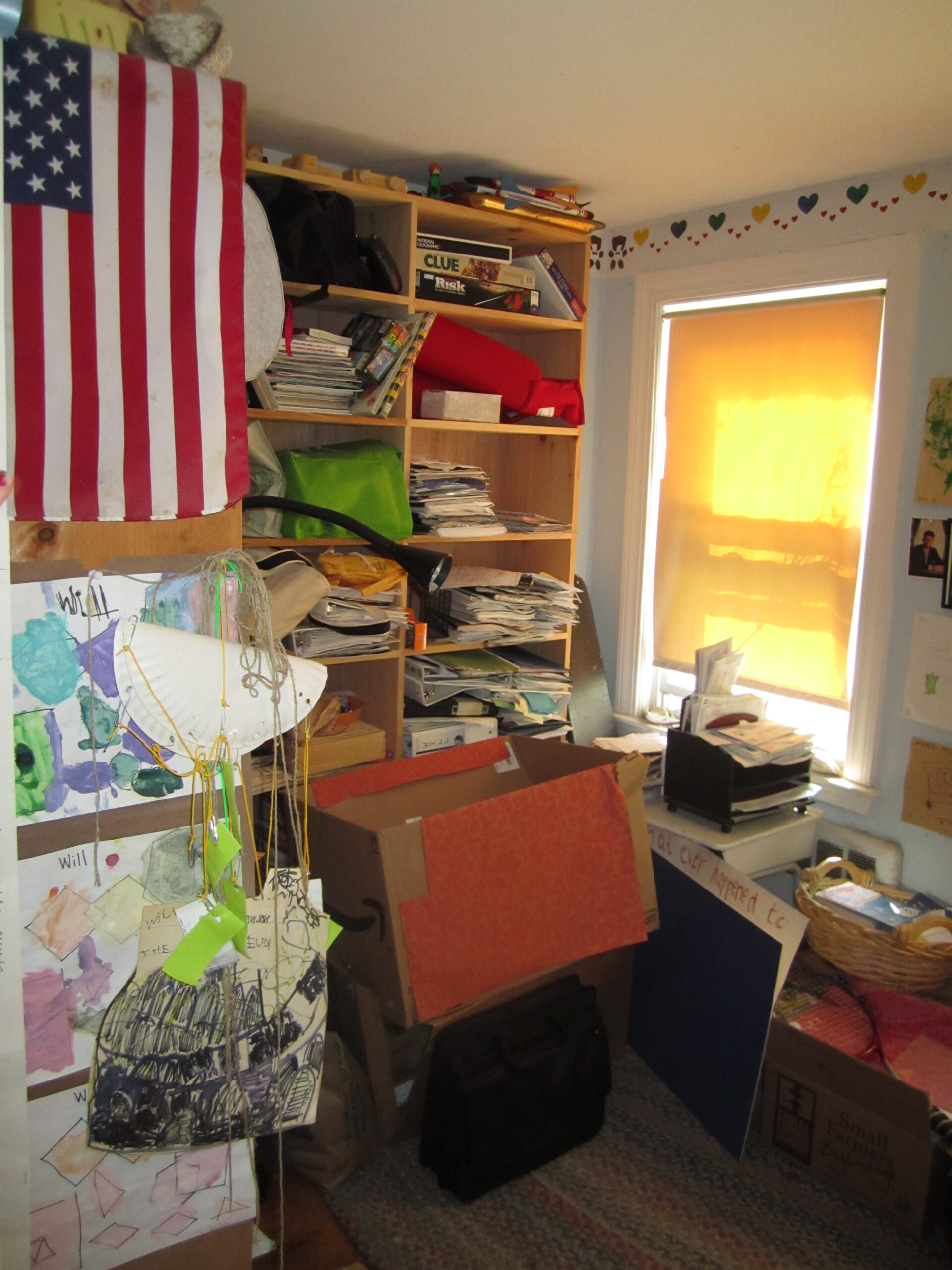 Open bookcase overflowing with books, decor, and miscellaneous clutter