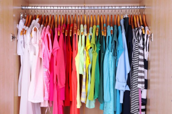 Colorful clothes hanging in wardrobe